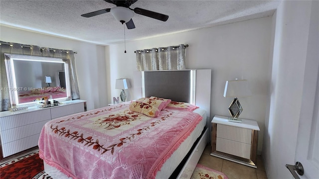 bedroom with tile patterned flooring, a textured ceiling, and a ceiling fan