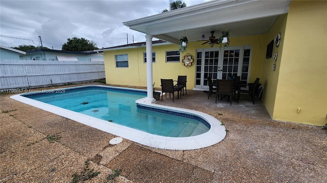 view of swimming pool with fence, french doors, a patio, a fenced in pool, and a ceiling fan