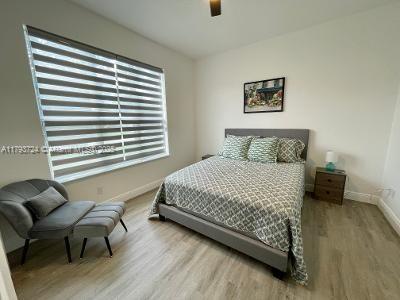 bedroom featuring baseboards, a ceiling fan, and wood finished floors