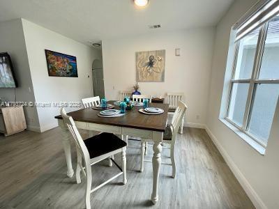 dining room featuring baseboards, arched walkways, and wood finished floors