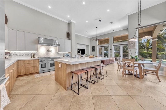 kitchen featuring extractor fan, double oven range, modern cabinets, tasteful backsplash, and recessed lighting