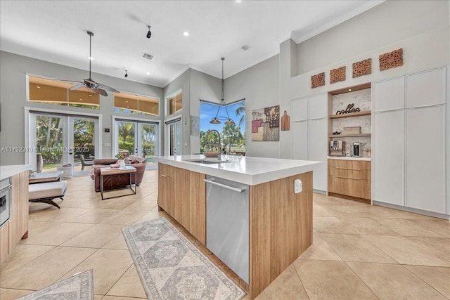 kitchen featuring a sink, french doors, light tile patterned floors, stainless steel dishwasher, and modern cabinets