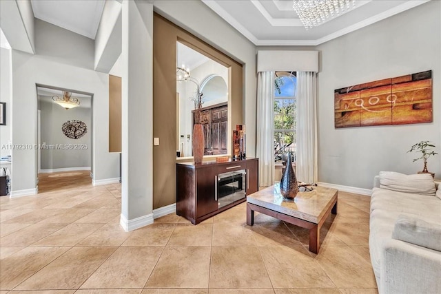 sitting room featuring an inviting chandelier, light tile patterned floors, baseboards, and crown molding