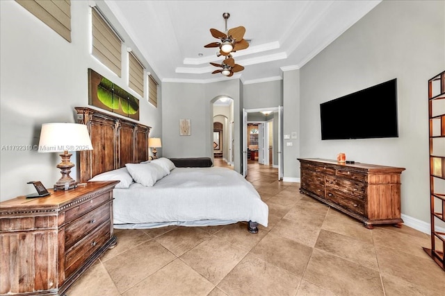 bedroom with light tile patterned floors, a tray ceiling, crown molding, baseboards, and arched walkways