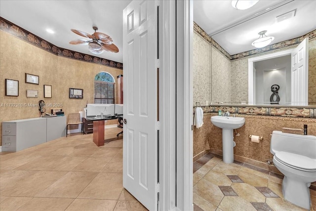 bathroom with tile patterned flooring, toilet, ceiling fan, and wallpapered walls