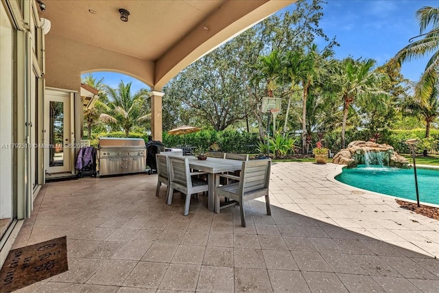 view of patio / terrace with area for grilling, an outdoor pool, and outdoor dining space