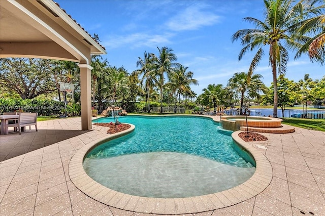 view of swimming pool featuring a patio, a pool with connected hot tub, and fence