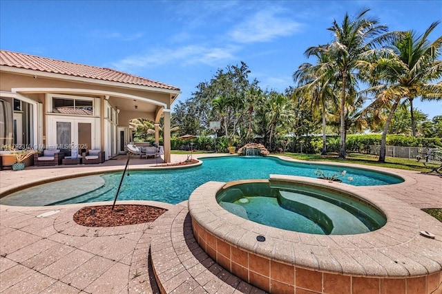 view of pool with a pool with connected hot tub, fence, a patio, and french doors