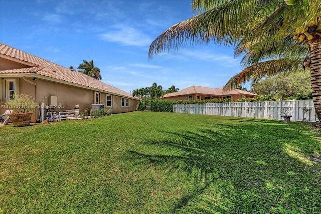 view of yard with a fenced backyard and central air condition unit