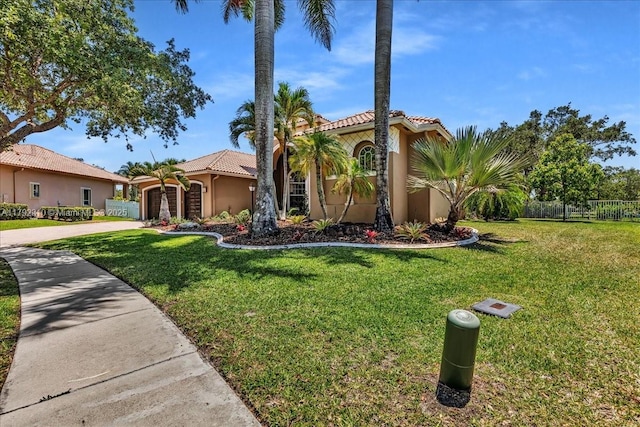 mediterranean / spanish-style house with a garage, a tiled roof, fence, concrete driveway, and a front yard