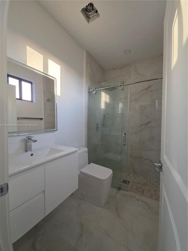 bathroom featuring toilet, a marble finish shower, marble finish floor, and vanity