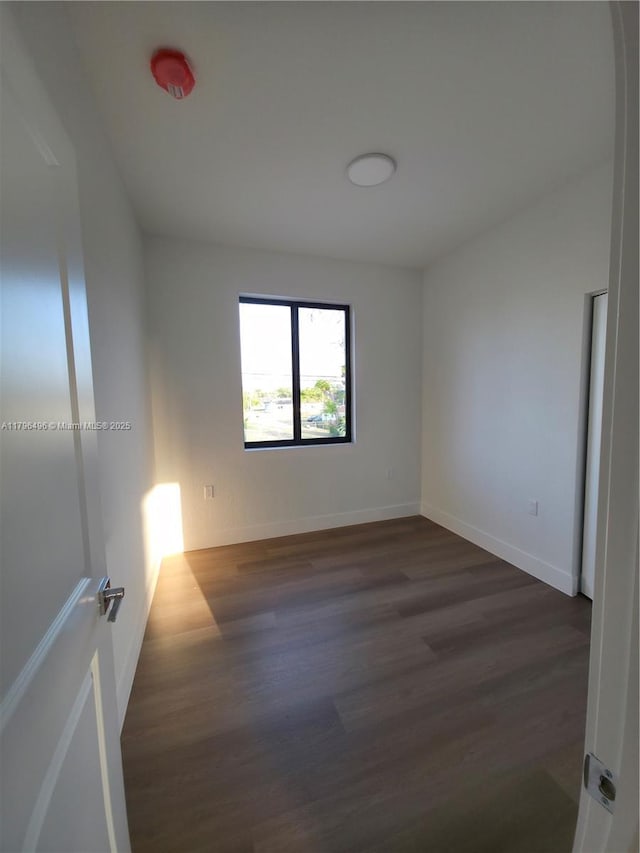 empty room featuring baseboards and wood finished floors