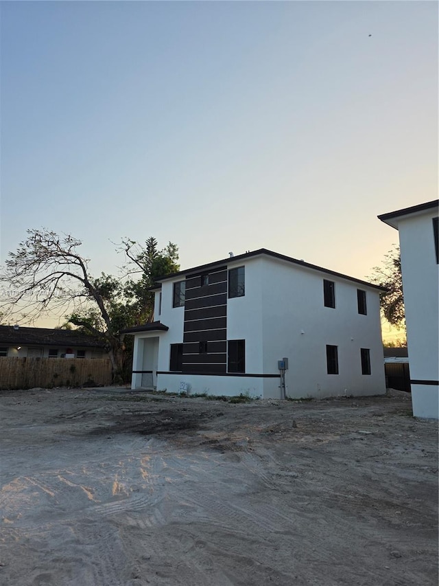 exterior space featuring stucco siding and fence
