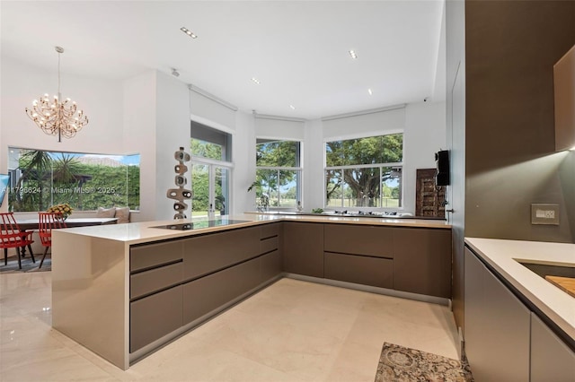kitchen with a wealth of natural light, modern cabinets, a chandelier, and gray cabinetry