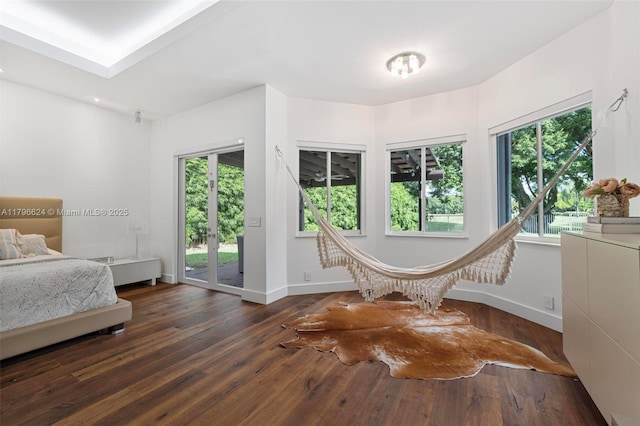 bedroom with multiple windows, access to outside, baseboards, and wood-type flooring