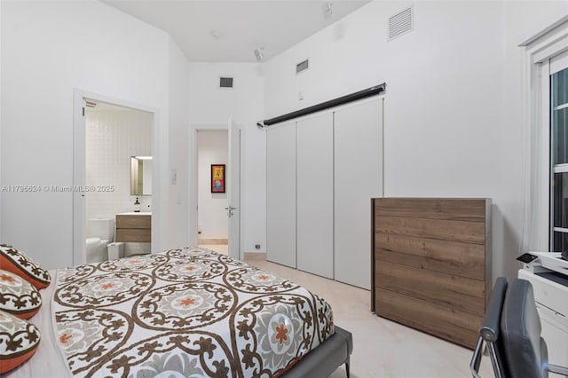 bedroom featuring connected bathroom, a closet, and visible vents
