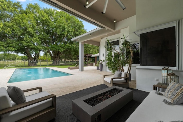 pool featuring an outdoor living space with a fire pit, fence, and a patio