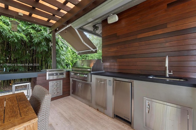 view of patio with a pergola, an outdoor kitchen, a sink, and grilling area