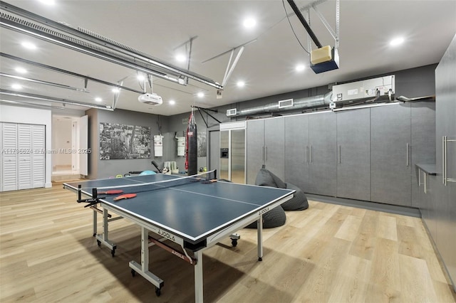 game room featuring visible vents, light wood-style flooring, a garage, and recessed lighting