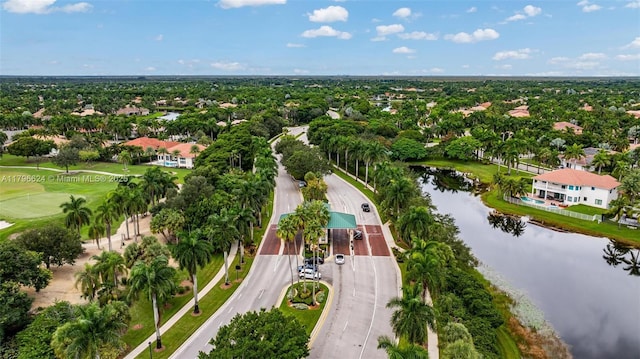 drone / aerial view with view of golf course, a water view, and a residential view