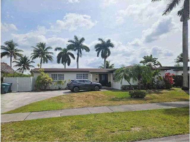 ranch-style home featuring a gate, stucco siding, fence, concrete driveway, and a front lawn