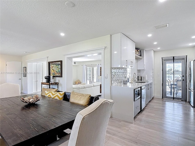 17931 NW 85th Ave, Hialeah, FL 33015 - kitchen with appliances with stainless steel finishes, light countertops, white cabinetry, light wood-type flooring, and modern cabinets