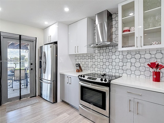 17931 NW 85th Ave, Hialeah, FL 33015 - kitchen with appliances with stainless steel finishes, wall chimney range hood, light countertops, light wood-type flooring, and recessed lighting