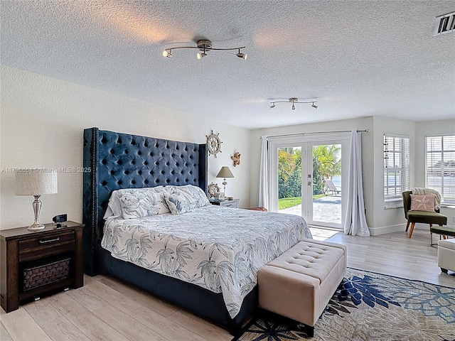 17931 NW 85th Ave, Hialeah, FL 33015 - bedroom featuring access to outside, light wood-style flooring, multiple windows, and a textured ceiling