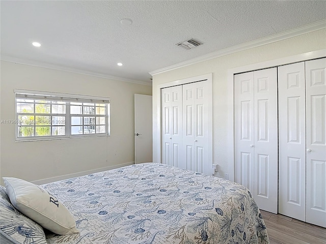 17931 NW 85th Ave, Hialeah, FL 33015 - bedroom with crown molding, two closets, light wood-style floors, a textured ceiling, and recessed lighting