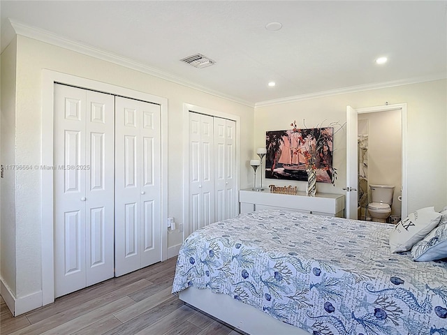 17931 NW 85th Ave, Hialeah, FL 33015 - bedroom featuring two closets, light wood finished floors, ornamental molding, recessed lighting, and ensuite bath