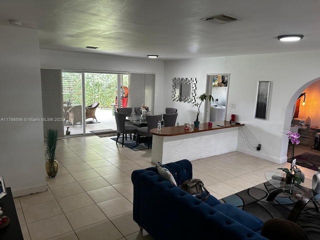 5718 Monroe St, Hollywood, FL 33023 - living area with arched walkways, baseboards, light tile patterned floors, and visible vents