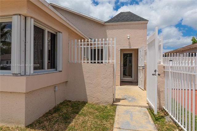 view of home's exterior with stucco siding and fence