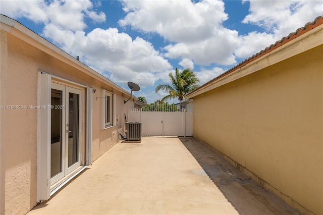 view of patio / terrace featuring cooling unit, french doors, and fence