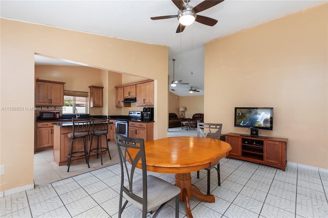 dining space with light tile patterned floors, baseboards, lofted ceiling, and a ceiling fan