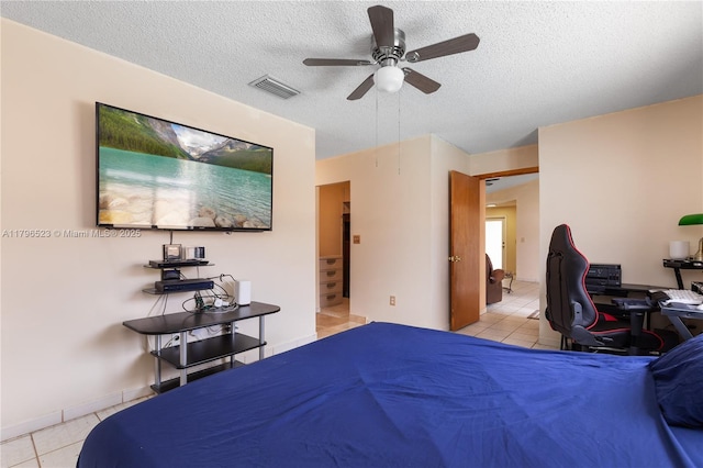 bedroom with light tile patterned floors, visible vents, ceiling fan, and a textured ceiling