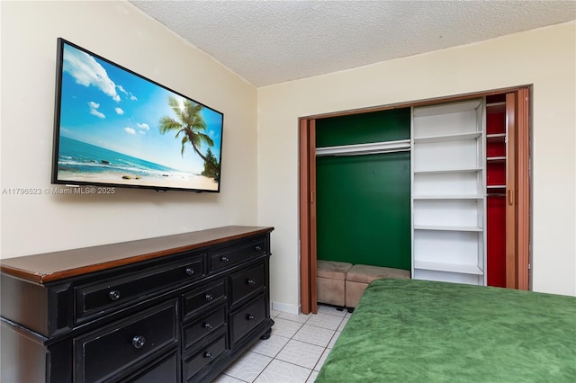 bedroom with light tile patterned floors, a closet, and a textured ceiling