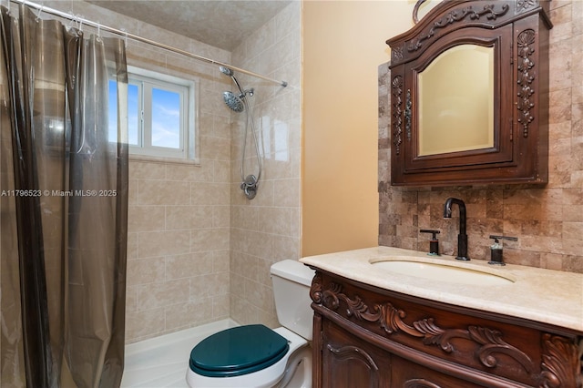 bathroom featuring toilet, decorative backsplash, vanity, and a tile shower