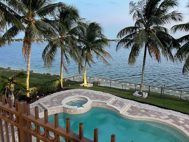 view of swimming pool with a water view, an in ground hot tub, a fenced in pool, and a fenced backyard