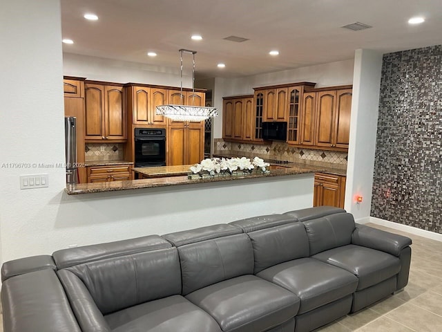 kitchen featuring brown cabinetry, open floor plan, black appliances, and glass insert cabinets