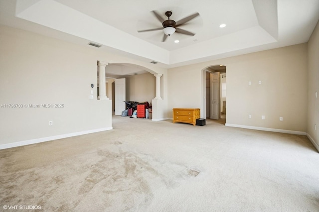 19058 SW 17th Ct, Miramar, FL 33029 - empty room featuring arched walkways, a raised ceiling, decorative columns, a ceiling fan, and light carpet