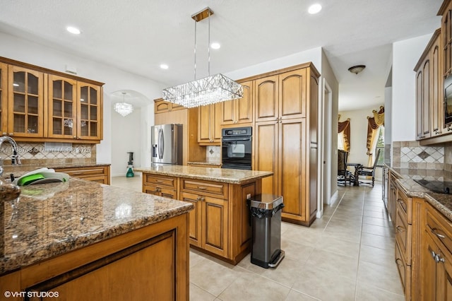 19058 SW 17th Ct, Miramar, FL 33029 - kitchen with black appliances, a kitchen island, backsplash, a sink, and brown cabinets