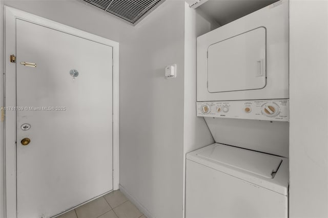 laundry room with stacked washing maching and dryer, laundry area, visible vents, and light tile patterned flooring