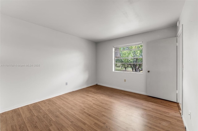 empty room with baseboards and light wood-style flooring