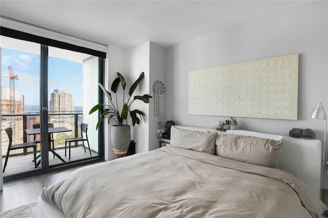 bedroom featuring a view of city, expansive windows, and access to exterior