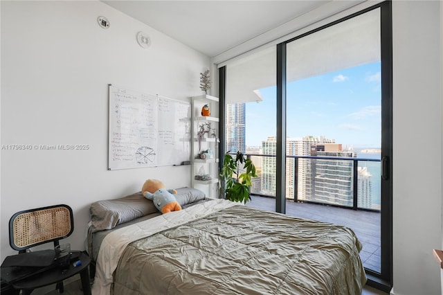 bedroom featuring a view of city, access to outside, and expansive windows