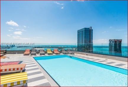 community pool with a patio area and a water view