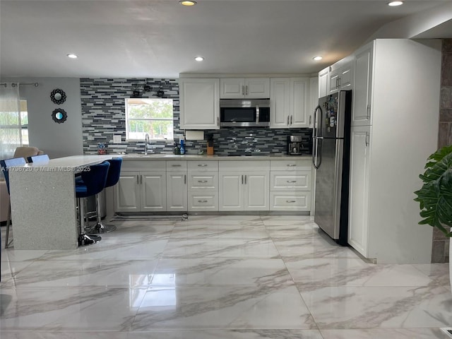 493 Camino Real Blvd, Clewiston, FL 33440 - kitchen with white cabinets, recessed lighting, stainless steel appliances, and backsplash