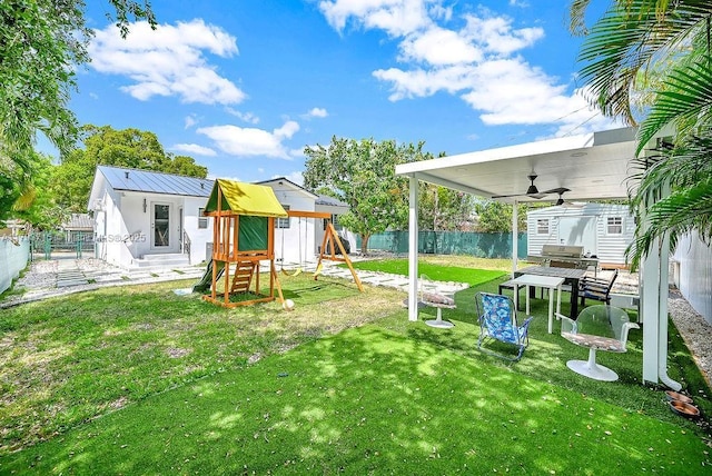 view of yard featuring a fenced backyard, an outdoor structure, a storage shed, and a playground