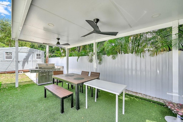 view of patio with fence, a storage shed, area for grilling, an outbuilding, and outdoor dining area