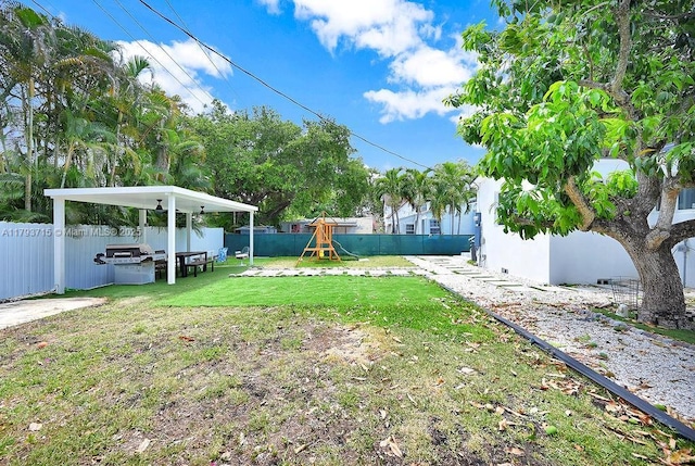 view of yard with a playground and a fenced backyard